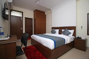 a hotel room with a bed and a desk and a computer at OYO Surya Palace in New Delhi