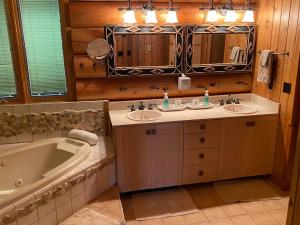 a bathroom with two sinks and a bath tub at Two Bear Lodge on Lost Land Lake in Hayward