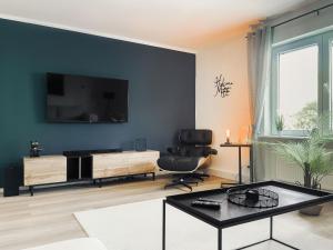 sala de estar con TV en una pared azul en NOVA Romantic Luxus Relax Apartments mit Sauna, Nürburgring, Adenauer Forst en Adenau