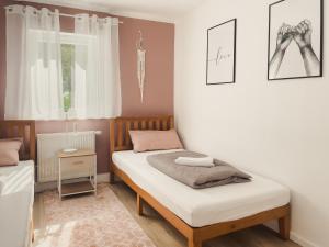 NOVA Romantic Luxus Relax Apartments mit Sauna, Nürburgring, Adenauer Forst في آدناو: غرفة نوم صغيرة بسريرين ونافذة