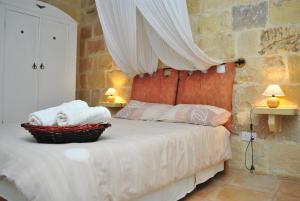 a bedroom with a bed with a canopy and two lamps at Dar Ghax-Xemx Farmhouse in Victoria