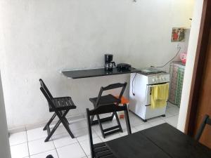 eine Küche mit 2 Stühlen, einem Tisch und einem Herd in der Unterkunft Betesda 2197E KITNET in São Luís