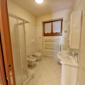 W łazience znajduje się toaleta, umywalka i prysznic. w obiekcie Comfortable Villa with private garden - Colico Center w mieście Colico