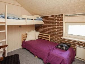 1 dormitorio con 1 cama en una pared de ladrillo en Three-Bedroom Holiday home in Blåvand 16, en Ho