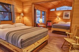 a bedroom with two beds in a log cabin at Big Sur Campground and Cabins in Big Sur