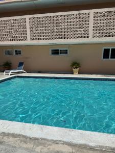 a swimming pool in front of a building at Remarkable 1-Bed Apartment in Montego Bay in Montego Bay