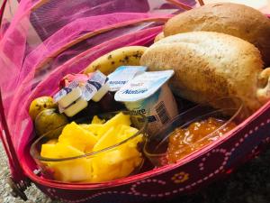 una cesta llena de comida con pan y fruta en Chez Moi en Chemin Grenier