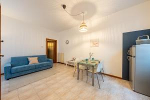 ein Wohnzimmer mit einem blauen Sofa und einem Tisch in der Unterkunft Verdi Bilo Roseto Vacanza in Roseto degli Abruzzi