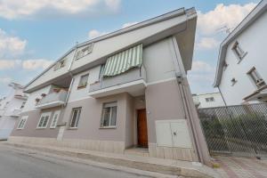 um edifício branco com uma porta e uma varanda em Verdi Bilo Roseto Vacanza em Roseto degli Abruzzi