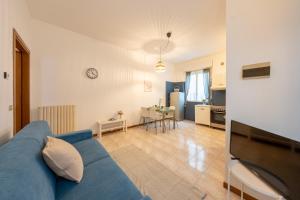 ein Wohnzimmer mit einem blauen Sofa und einer Küche in der Unterkunft Verdi Bilo Roseto Vacanza in Roseto degli Abruzzi