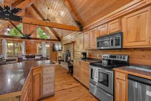 uma cozinha com armários de madeira e um forno com placa de fogão em Main Lodge at Lake Forest Cabins em Eureka Springs