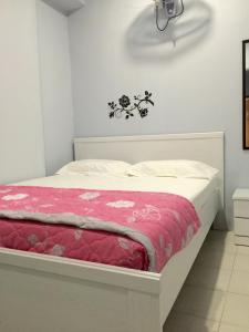 a bedroom with a white bed with a pink blanket at The Second Room in Ranau