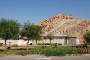 a building with a mountain in the background at Green Mubazzarah Chalets in Al Ain