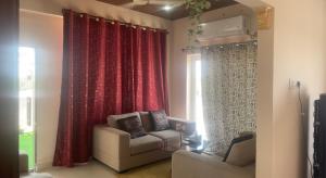 uma sala de estar com cortinas vermelhas e um sofá em Reef Terrace Unit em Hyderabad