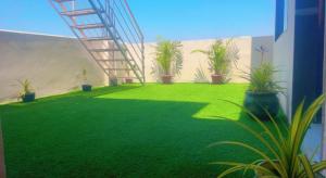 a green yard with plants and a staircase at Reef Terrace Unit in Hyderabad