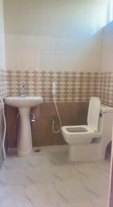 a bathroom with a toilet and a sink at Reef Terrace Unit in Hyderabad
