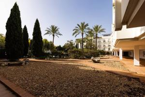 un patio con palmeras y un edificio en Stunning Duplex 5 minutes from Puerto Banús, en Marbella