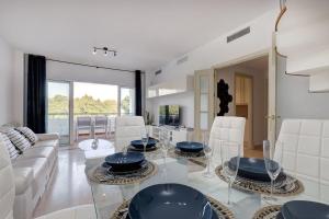 sala de estar con mesa de cristal y sillas blancas en Stunning Duplex 5 minutes from Puerto Banús, en Marbella