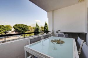 una mesa blanca con copas de vino en el balcón en Stunning Duplex 5 minutes from Puerto Banús, en Marbella