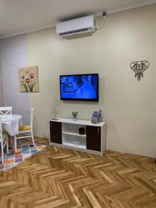 ein Wohnzimmer mit einem Flachbild-TV an der Wand in der Unterkunft IGNIM 2 Apartment in Subotica