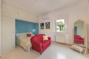una camera con una sedia rossa e un letto di Podere Isabella a San Vincenzo