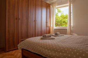 ein Schlafzimmer mit einem Bett mit zwei Handtüchern darauf in der Unterkunft Apartment Stella Marina in Rabac