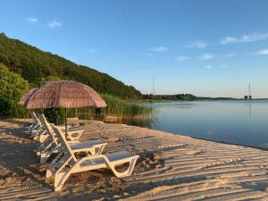 two lounge chairs and an umbrella on a beach at Lawendowa Przystań WICKO 3 km od Międzyzdrojów in Międzyzdroje
