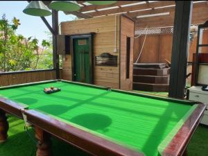 a pool table in a backyard with a house at The Pearl of the Golan - Pnina BaGolan in Had Nes