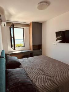 um quarto com uma cama e uma janela em Carobno jutro em Rafailovici