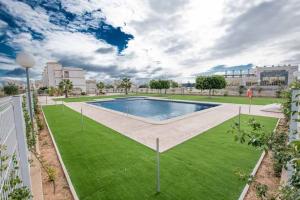 una piscina en un parque con césped verde en Casa Flamingo Private Residence, en Orihuela