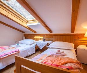 a attic room with two beds and a skylight at Room Kaštelan in Cres +2 photos