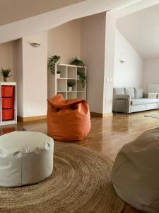 uma sala de estar com dois repousa-pés e um sofá em Bonbillo - ONGI ETORRI em Zumaia