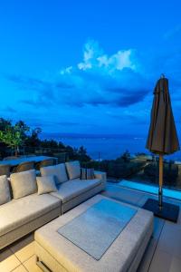 sala de estar con sofá y vistas al océano en Villa Aura Caesar - 5 Bedroom villa - Ultra modern and luxurious - Stunning sea and town views, en Medveja