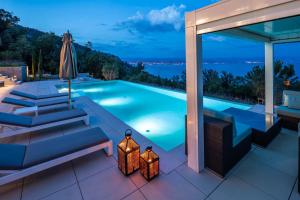 una piscina en una villa por la noche en Villa Aura Caesar - 5 Bedroom villa - Ultra modern and luxurious - Stunning sea and town views, en Medveja
