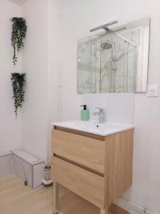 a bathroom with a sink and a mirror at ° Appart' Audincourt 2 centre ° in Audincourt