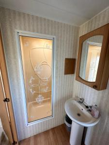 a bathroom with a sink and a mirror at Static Caravan in Pwllheli +8 photos