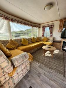 a living room with a couch and a table at Static Caravan in Pwllheli