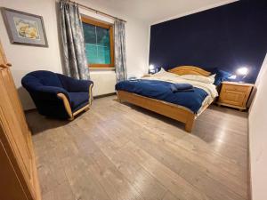 a bedroom with a bed and a chair and a window at Ferienwohnung Lisal in Mutters