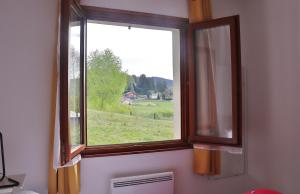 una ventana con vistas a un campo verde en Les Sapins du Tholy, en Le Tholy