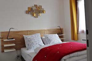 1 dormitorio con 1 cama con manta roja y 2 lámparas en Les Sapins du Tholy, en Le Tholy