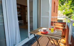un tavolo su un balcone con 2 tazze di succo d'arancia di [Suite con Piscina] WiFi - Netflix - Mare a 7 Min a Varazze