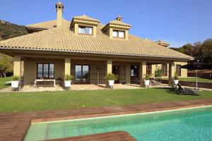 une maison avec une piscine en face d'une maison dans l'établissement LA HOYA ALCORNOCALES, à Benalup-Casas Viejas