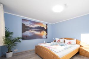 a bedroom with a bed with a painting on the wall at Familienfreundliche 3-Zimmer-Ferienwohnung in Saal an der Donau +2 photos