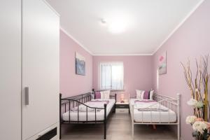 two beds in a room with pink walls at Familienfreundliche 3-Zimmer-Ferienwohnung in Saal an der Donau