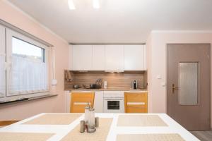 a kitchen with white cabinets and a large window at Familienfreundliche 3-Zimmer-Ferienwohnung in Saal an der Donau