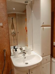 een badkamer met een witte wastafel en een spiegel bij Old Town Center Spacious Loft Apartment, up to 4 guests in Rīga