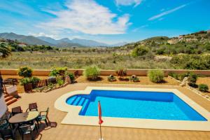 una piscina en un patio con mesa y sillas en Quicano - magnificent views and private pool in Lliber, en Lliber