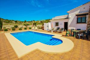 una piscina en un patio trasero con mesa y sillas en Quicano - magnificent views and private pool in Lliber, en Lliber