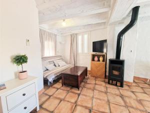 uma sala de estar com um fogão e um sofá em EL BOTIJO Las puertitas rojas em Ubrique