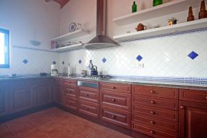 una cucina con mobili in legno e piastrelle bianche e blu di CASA CAN PARRA a Sant Francesc Xavier